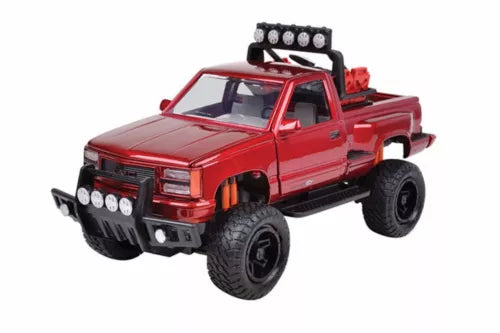 Red 1/24 scale diecast pickup truck with black grille and roof light bar