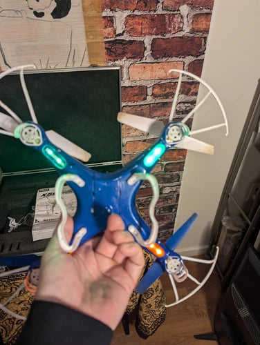 Blue 4-rotor RC drone with LED lights and four propeller blades