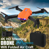 Foldable quadcopter drone with orange battery pack and black remote controller