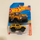 Yellow Hot Wheels 1/10 Ford Bronco diecast truck in retail blister pack, front view