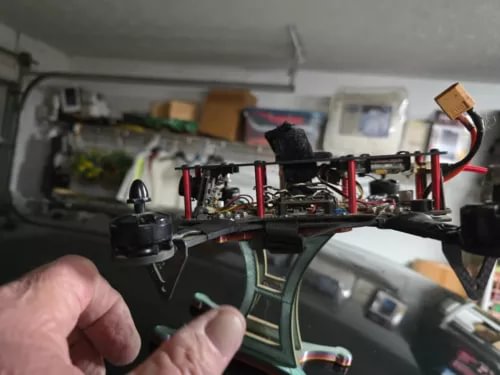 RC quadcopter drone with red-and-black frame and black prop guards