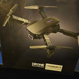 Quadcopter drone with four propellers, folded arms, and front LED