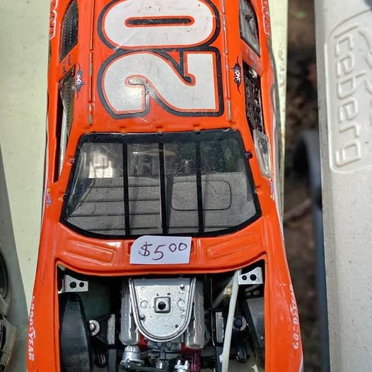 Orange diecast NASCAR race car with open hood and engine detail