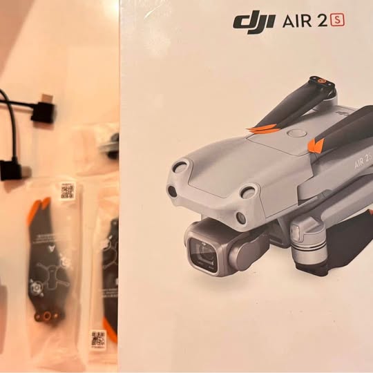 DJI Air 2S drone with camera, folded arms, light gray body and orange accents