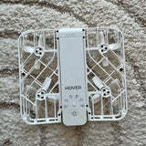 Hover camera drone with folded prop guards and central camera module