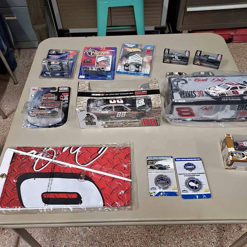 Assorted diecast NASCAR collectible cars in blister packs and accessories, on display