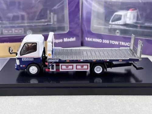 White diecast flatbed tow truck model with metal bed and wheels, front three-quarter view