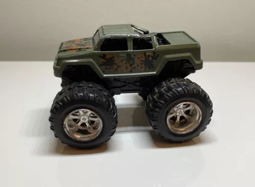 Monster truck diecast toy with camo body and black oversized tires