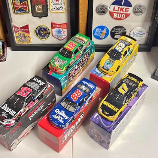 Assorted diecast model cars in retail boxes, multi-color with visible race numbers