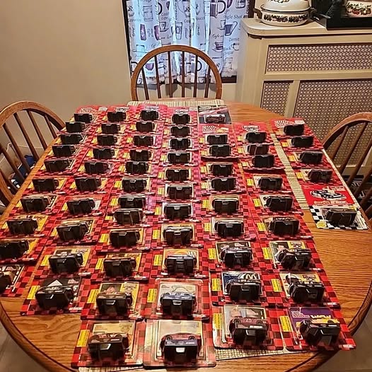 Set of 1:64 diecast race cars in blister-style packages, rows on a table