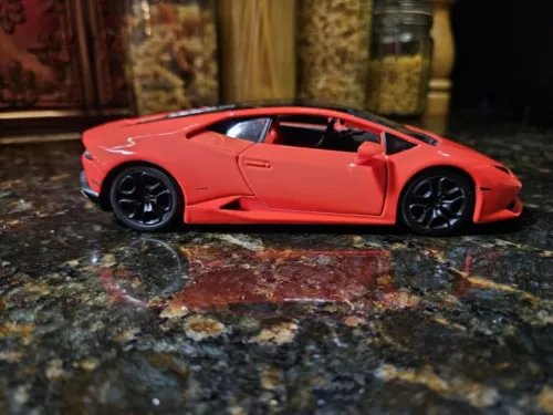 Lamborghini Huracan red diecast sports car with black wheels, side view