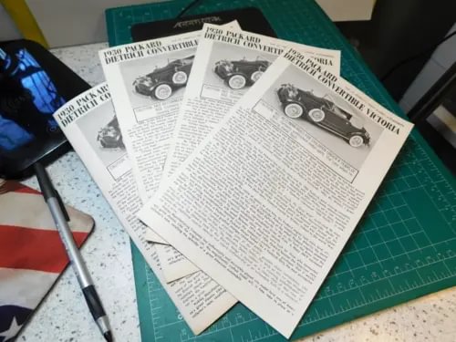 Paper brochure pages for a diecast car model, black-and-white text with small diagrams