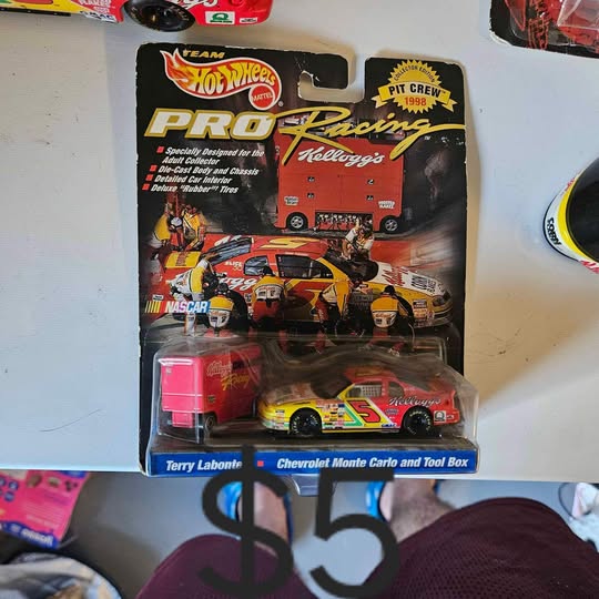 Diecast stock car model with tool box, red and yellow, in retail blister pack