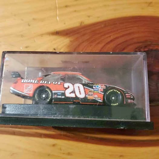 NASCAR diecast race car, orange/black with #20 and Home Depot branding