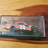 NASCAR diecast race car, orange/black with #20 and Home Depot branding