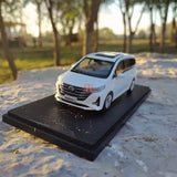 White GM6 MPV diecast model car with front grille detail on black display base