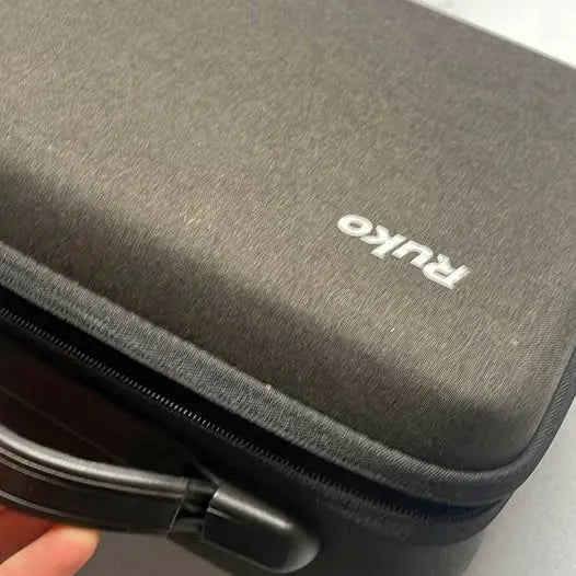 Gray fabric drone carrying case with zipper and Ruku logo patch