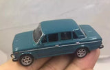 Teal 1:64 diecast sedan model car with black windows, front three-quarter view