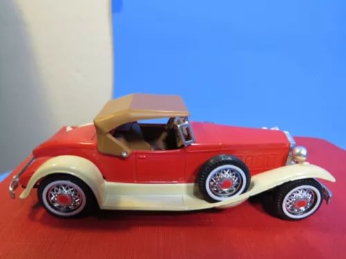 Red and cream diecast boattail speedster model car with tan interior, front 3/4 view