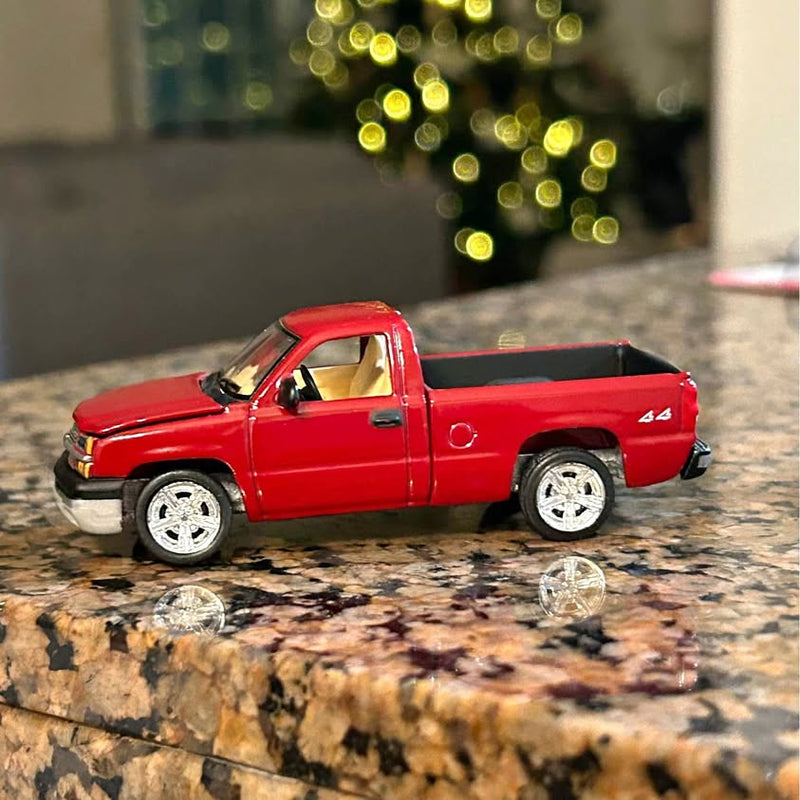 Red 1/64 diecast pickup truck with black bed and chrome wheels