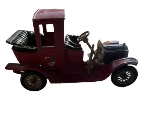 Maroon vintage diecast model car with open top and detailed grille, side view