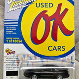 Black die-cast muscle car model in clear blister on yellow blue card