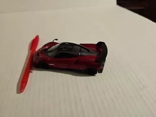 Red diecast model sports car with black hood and open door