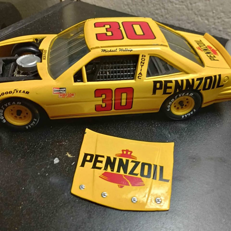 Yellow 1/24 diecast race car with red “30”, Pennzoil logo, and separate Pennzoil panel