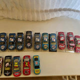 1:64 NASCAR diecast race car assortment in clear display boxes, row on shelf