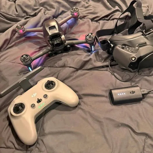 DJI FPV drone controller with antenna and drone frame, plus battery pack