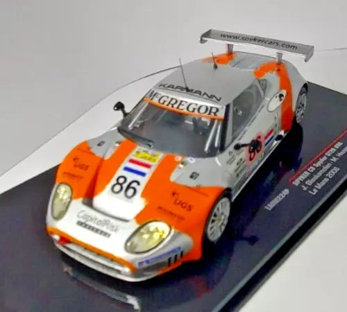 Orange and white diecast race car model with number 86 on hood, 1/43 scale