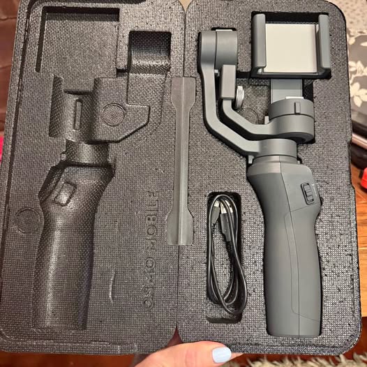 DJI Osmo Mobile 2 smartphone gimbal stabilizer in gray case with charging cable