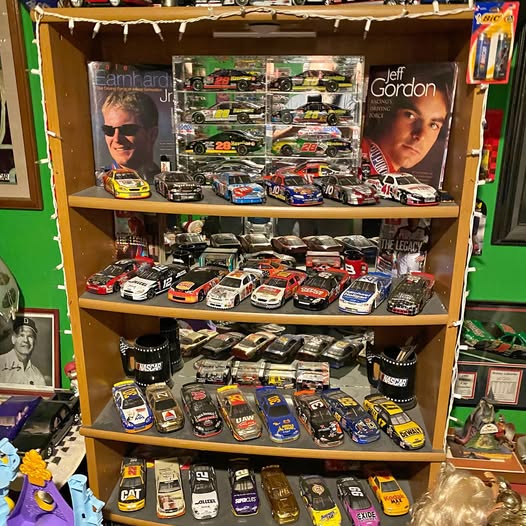 Wooden display rack with rows of colorful diecast toy cars