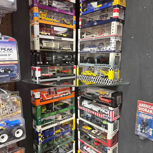 Diecast car toy shelf with boxed vehicles in colorful packaging