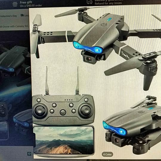 Gray quadcopter drone with blue LED lights and camera, plus remote controller