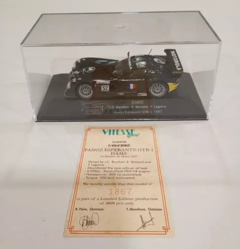 Diecast race car model in clear display case, dark body with #52 detailing