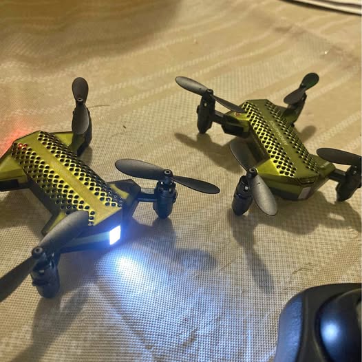 Drone set with controller: two green quadcopter drones with LED lights