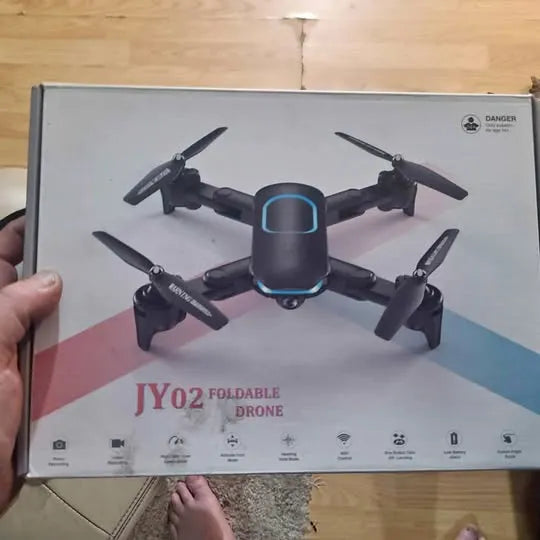 Foldable drone with camera box with illustrated quadcopter and warning label