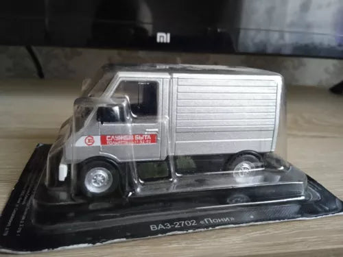 Grey diecast USSR-style truck model in display case, front three-quarter view