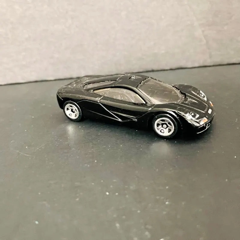 McLaren F1 black diecast sports car with silver stripes, collectible toy model