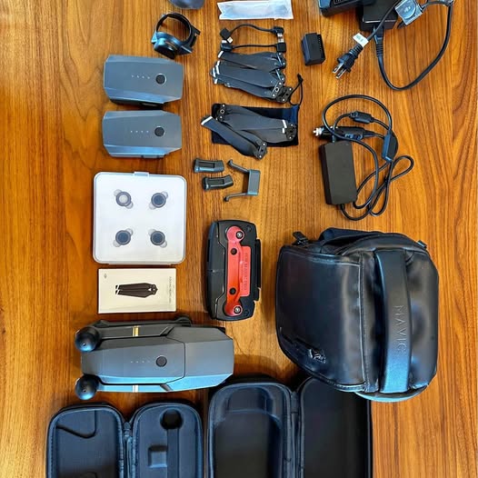 DJI drone accessory kit in black cases with controller, batteries, and cables