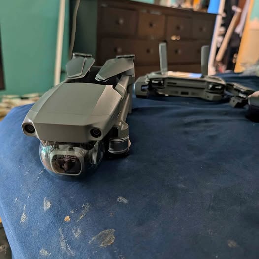 Foldable quadcopter drone, light gray, front camera and propellers folded