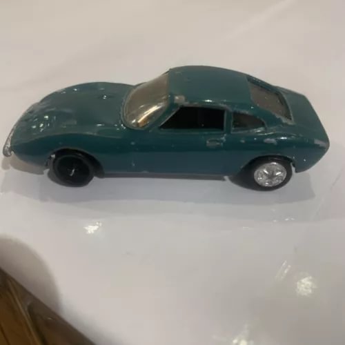 Used diecast vintage car model, teal, side view with wheels and headlights.