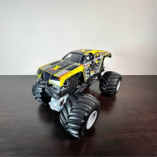 1:24 diecast monster truck with black and neon yellow body and oversized treaded tires