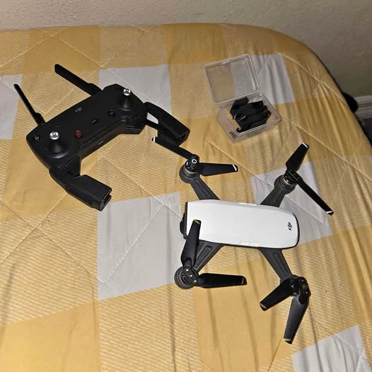 Foldable white quadcopter drone with four black propellers and compact body