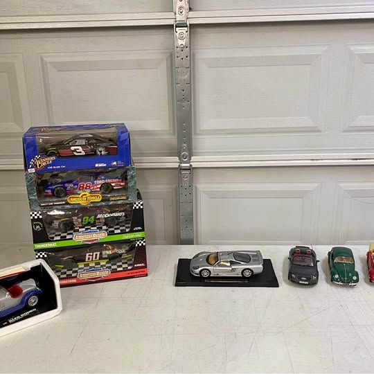 Diecast car collection set with four miniature race cars, including silver and green models
