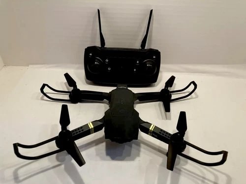 Black collapsible quadcopter drone with four propellers and attached controller