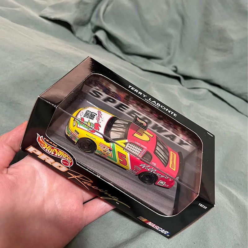 Diecast race car in Hot Wheels box with red, yellow #5 graphics