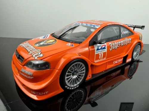 Orange and black diecast coupe model car with front three-quarter view