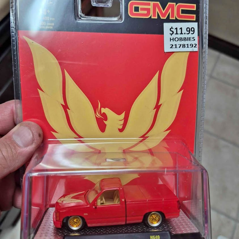 GMC red diecast truck model in clear blister package